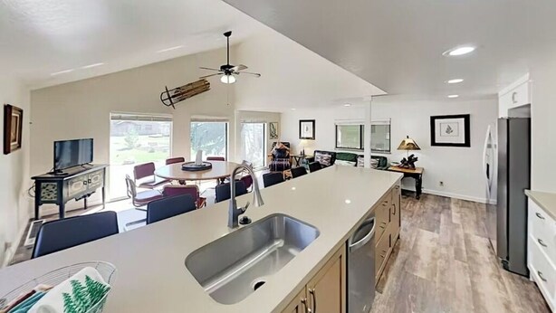 A modern kitchen with a large island, built-in appliances, and a dining area with chairs and a table. - Mountain Hideaway - Hot Tub, 3 Living Areas, 5 min. to Shop/Ski (Park City)