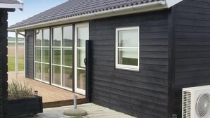 A black building with a large sliding glass door and a small window.