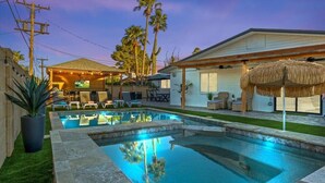 A swimming pool with a patio area, lounge chairs, and a covered seating area with a TV. - Just Listed! Old Town Paradise W/htd Pool & Spa! (Scottsdale)
