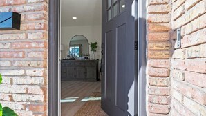 A hallway leading to a kitchen with a wooden cabinet and a large mirror. - Just Listed! Old Town Paradise W/htd Pool & Spa! (Scottsdale)
