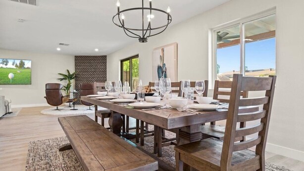 A dining area with a long wooden table set for six, surrounded by wooden chairs. - Just Listed! Old Town Paradise W/htd Pool & Spa! (Scottsdale)