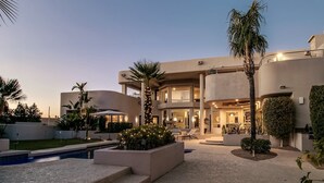 A modern multi-story house with a swimming pool, outdoor seating, and well-maintained landscaping. - Stunning Private & Modern N. Scottsdale Estate! (Scottsdale)