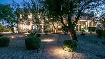 Vista frontal de la propiedad por la tarde o noche