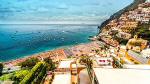 Un pueblo costero con playa, barcos y edificios de colores.