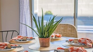 A dining table with a potted plant, plates, and cutlery.