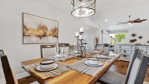 Een eetgedeelte met een houten tafel voor vier personen, omringd door stoelen.