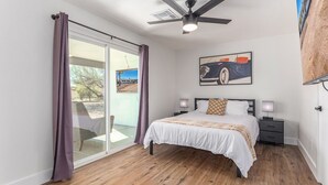 A bedroom with a bed, a ceiling fan, a nightstand, a lamp, and a painting on the wall. - NEW 7bdrm-4ba Million+ Estate W/amazing Amenities (Phoenix)