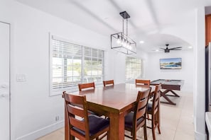 A dining area with a large wooden table and chairs, a ceiling fan, and a pool table. - NEW 7bdrm-4ba Million+ Estate W/amazing Amenities (Phoenix)