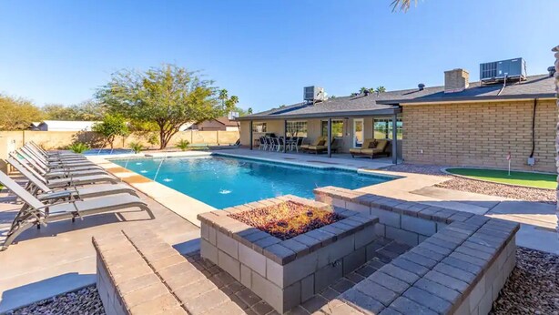 A backyard with a swimming pool, lounge chairs, a fire pit, and a patio area. - NEW 7bdrm-4ba Million+ Estate W/amazing Amenities (Phoenix)