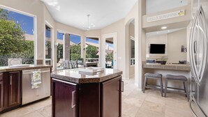 A modern kitchen with a large island, built-in appliances, and a view of the backyard. - Amazing Home in Great Location W/backyard Oasis! (Scottsdale)