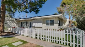 A single-story house with a white picket fence, a covered porch, and a small front yard with a tree. - Cozy Arcadia Hideaway W/charm & Style! (Phoenix)