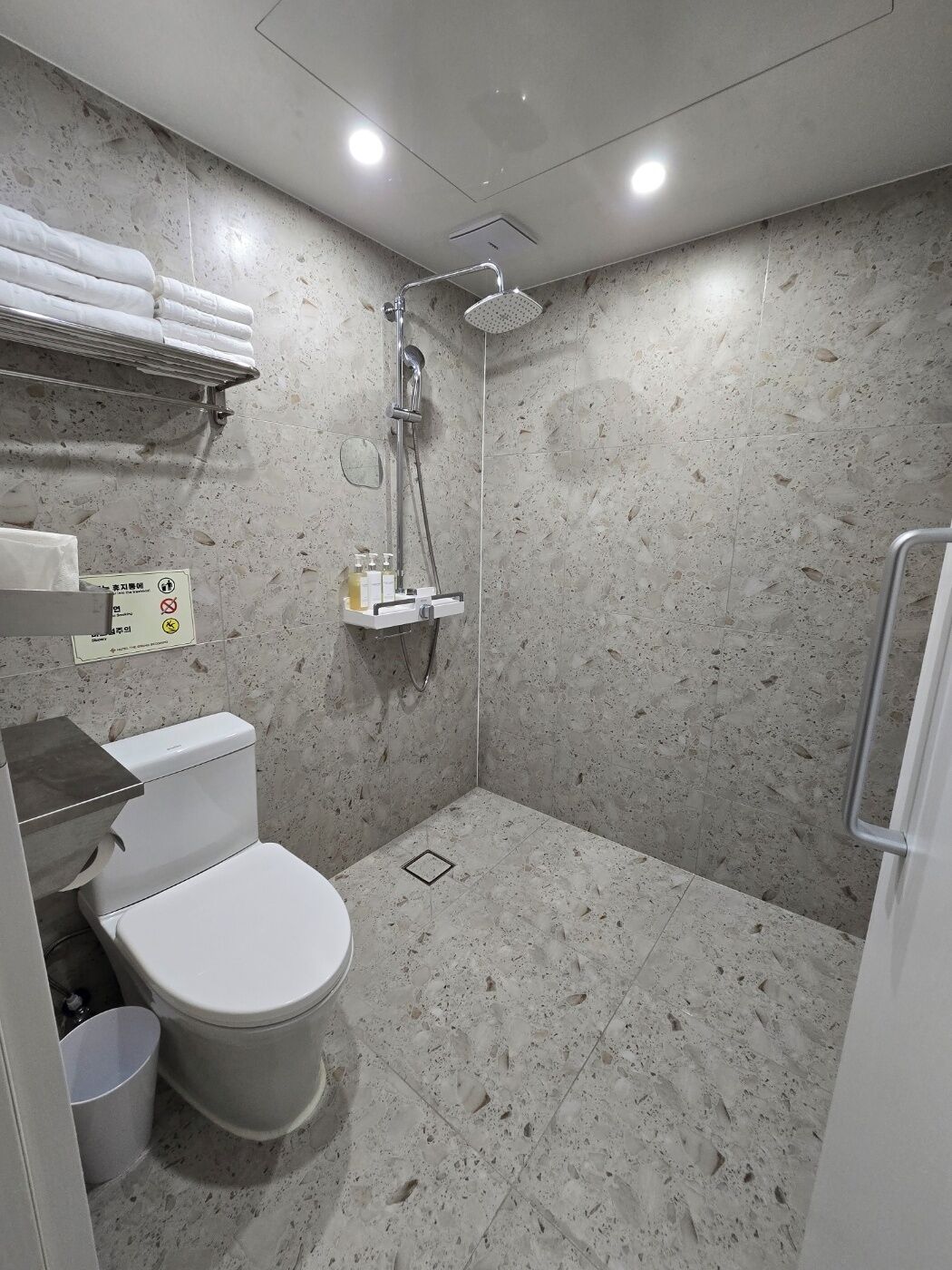 A compact bathroom with a toilet, sink, and shower.