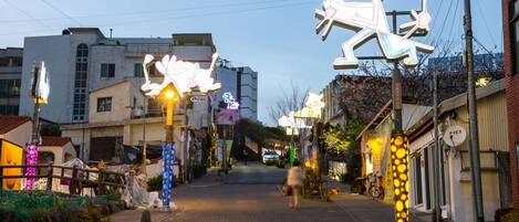 A street with illuminated sculptures and a paved walkway.
