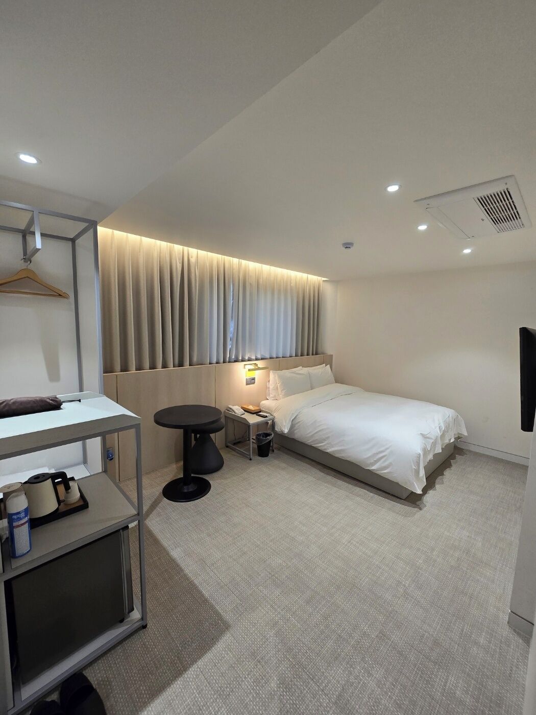 Une chambre d’hôtel moderne équipée d’un lit, d’une table de chevet et d’un bureau avec une chaise.