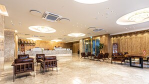 A spacious lobby with a reception desk, leather seating, and a large dining table. - Hotel The Grang Seogwipo (Seogwipo)