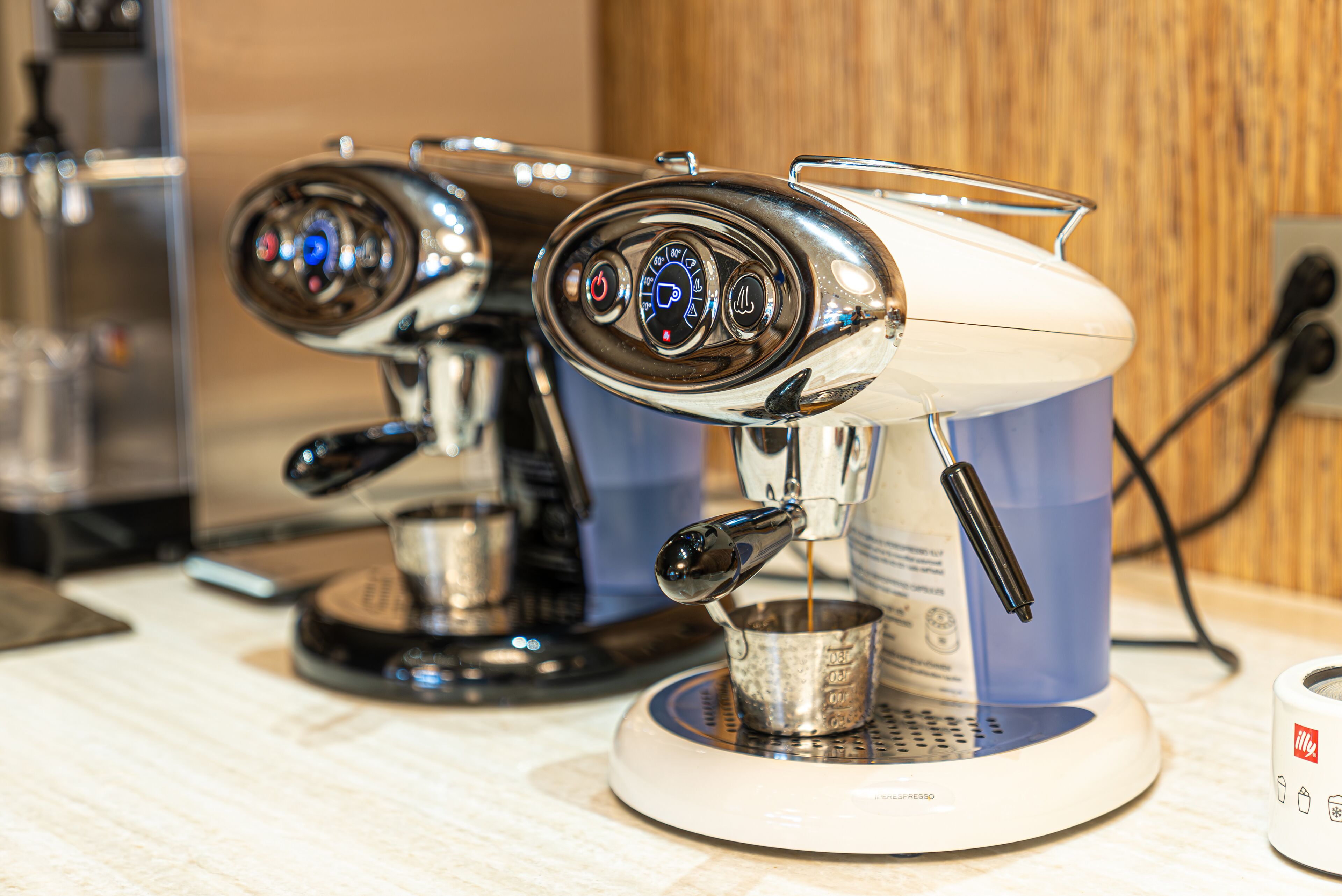 A coffee machine with a digital display and a milk frother.