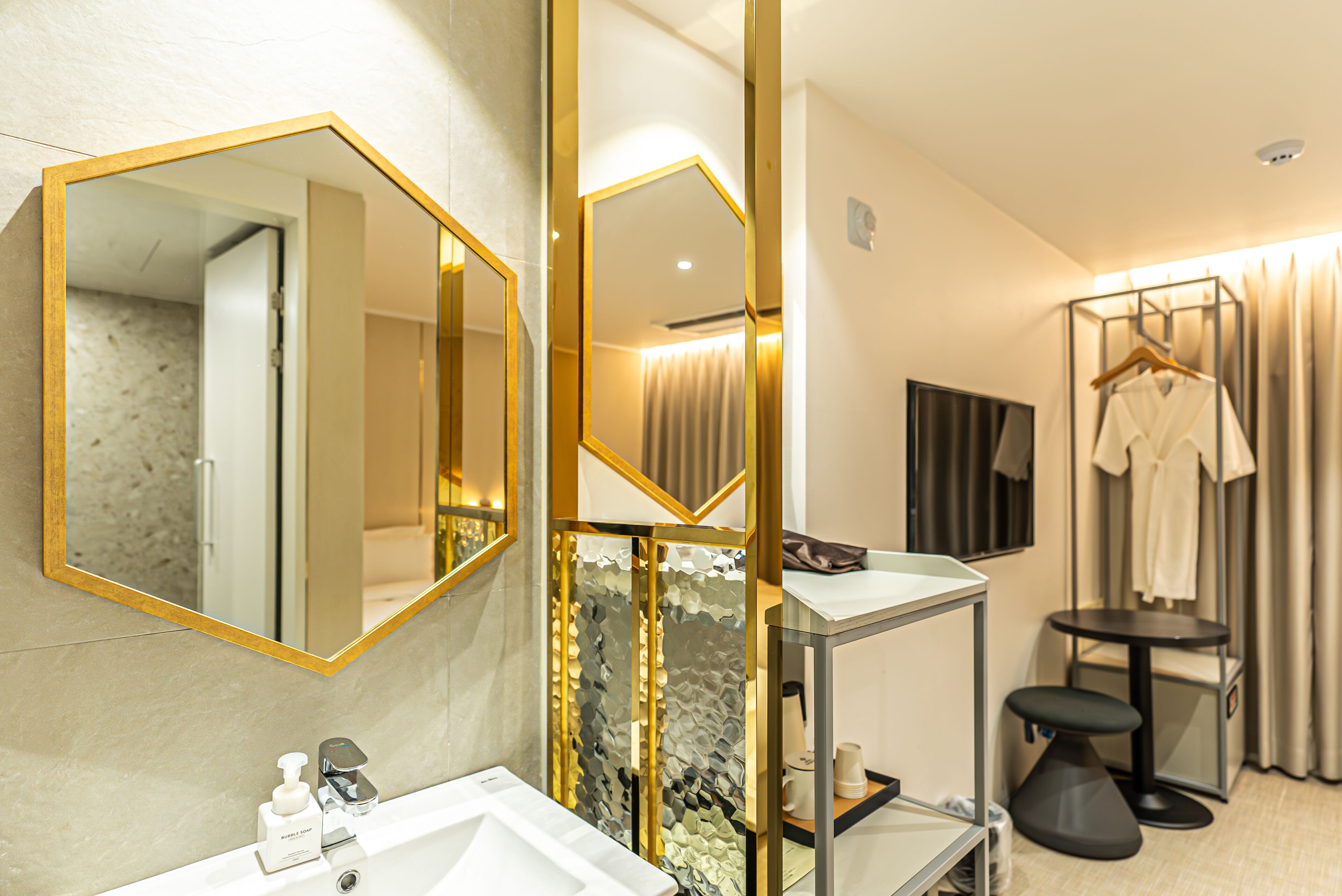 A modern bathroom with a large mirror, a sink, and a vanity with a mirror.