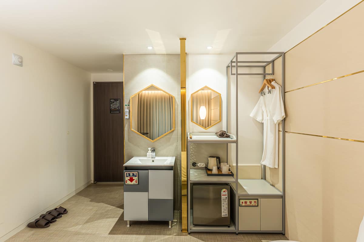 Een moderne badkamer met een wastafel, spiegel, handdoekhouder en een klein kastje.