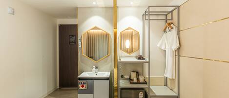 A modern bathroom with a sink, mirror, towel rack, and a small cabinet.
