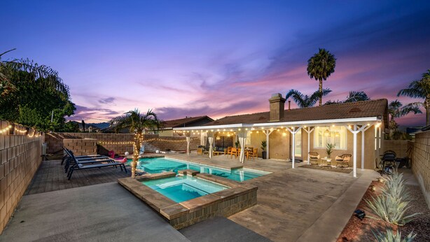 A backyard with a swimming pool, patio furniture, and a covered seating area. - Boho Bungalow - 30ft pool & minutes from festivals  (Indio)