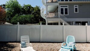 A swimming pool with two lounge chairs and a white fence. - PRIVATE Pool w/ Lithium  Golf Cart w paid parking INCLUDED. Walk to Restaurants (Oak Island)