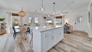 A spacious kitchen with a large island, white cabinetry, and hanging pendant lights. - Reel' Em Inn- A boater's paradise! (Orange Beach)