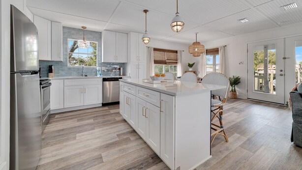 A spacious kitchen with white cabinetry, a large island, and pendant lighting. - Reel' Em Inn- A boater's paradise! (Orange Beach)