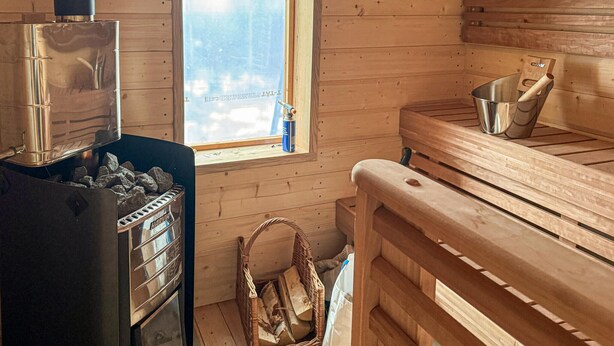 Una sauna con una panchina in legno, una finestra e vista panoramica.