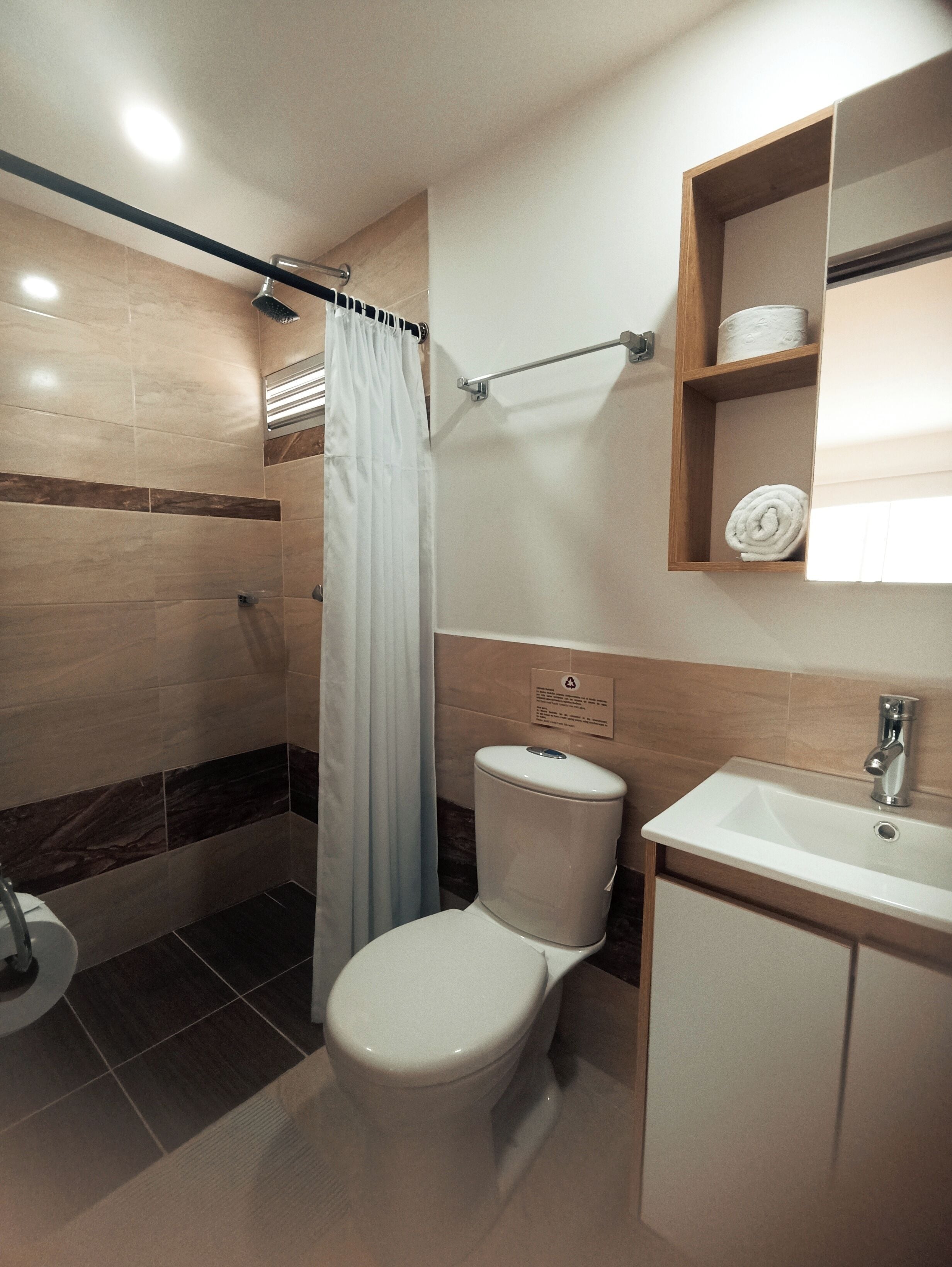 Un baño moderno con ducha, inodoro y lavabo.