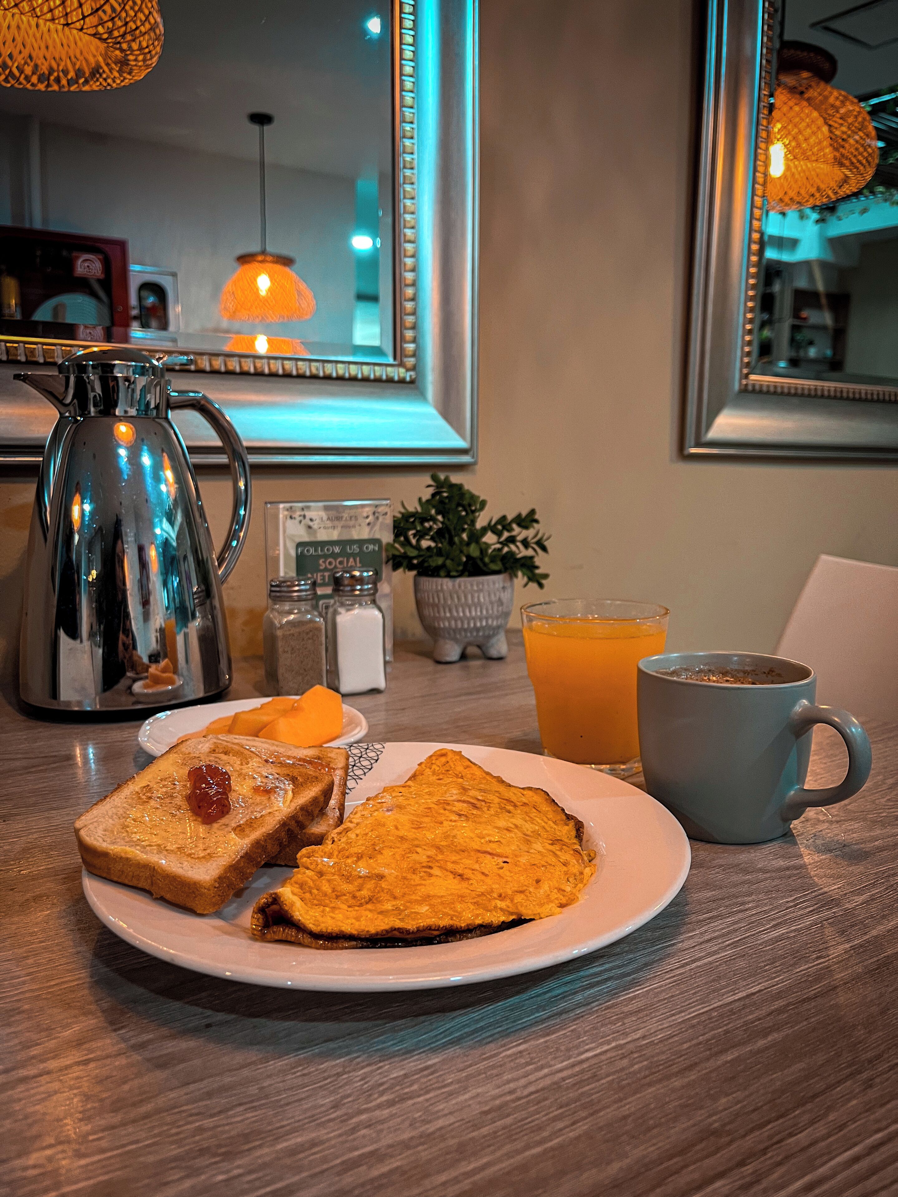 A breakfast setting with toast, a mug, and a glass of orange juice on a table.