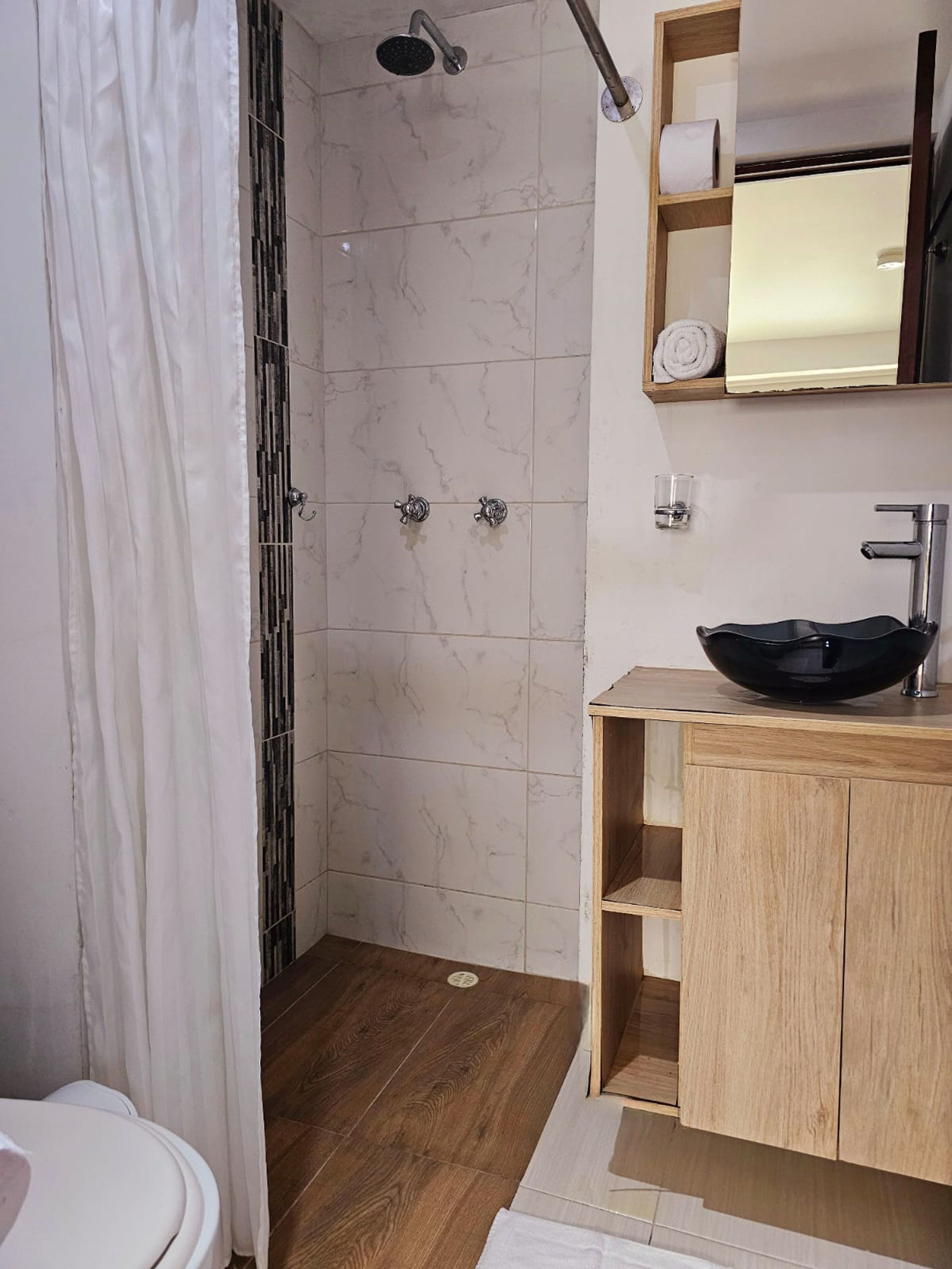 Un baño moderno con ducha, inodoro y tocador.