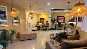 A modern hotel lobby with a seating area, large mirrors, and decorative lighting. - Laureles Grand House LGH Hotel - Anteriormente Laureles Guest House (Medellín)