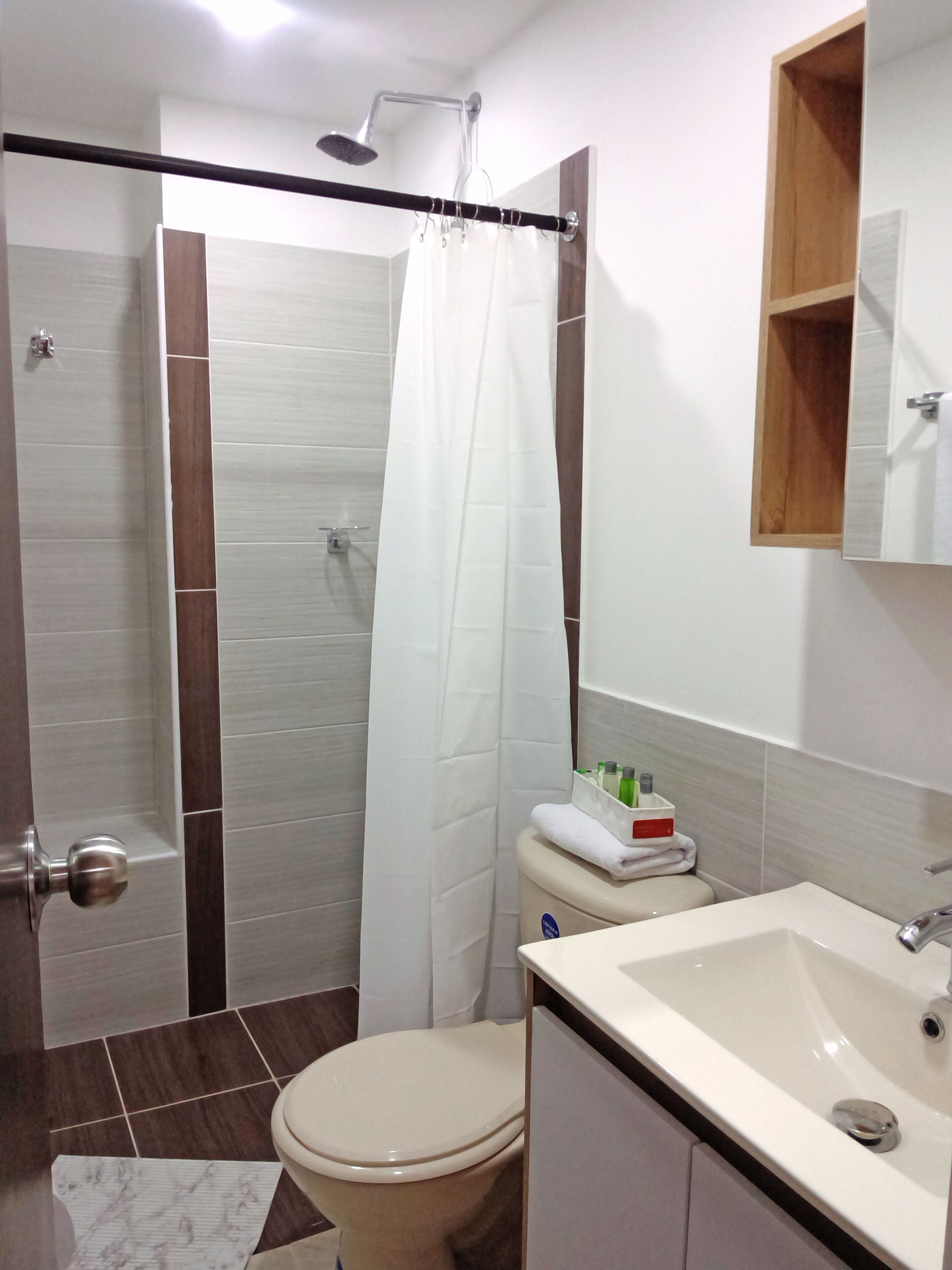 A bathroom with a shower, toilet, and sink.