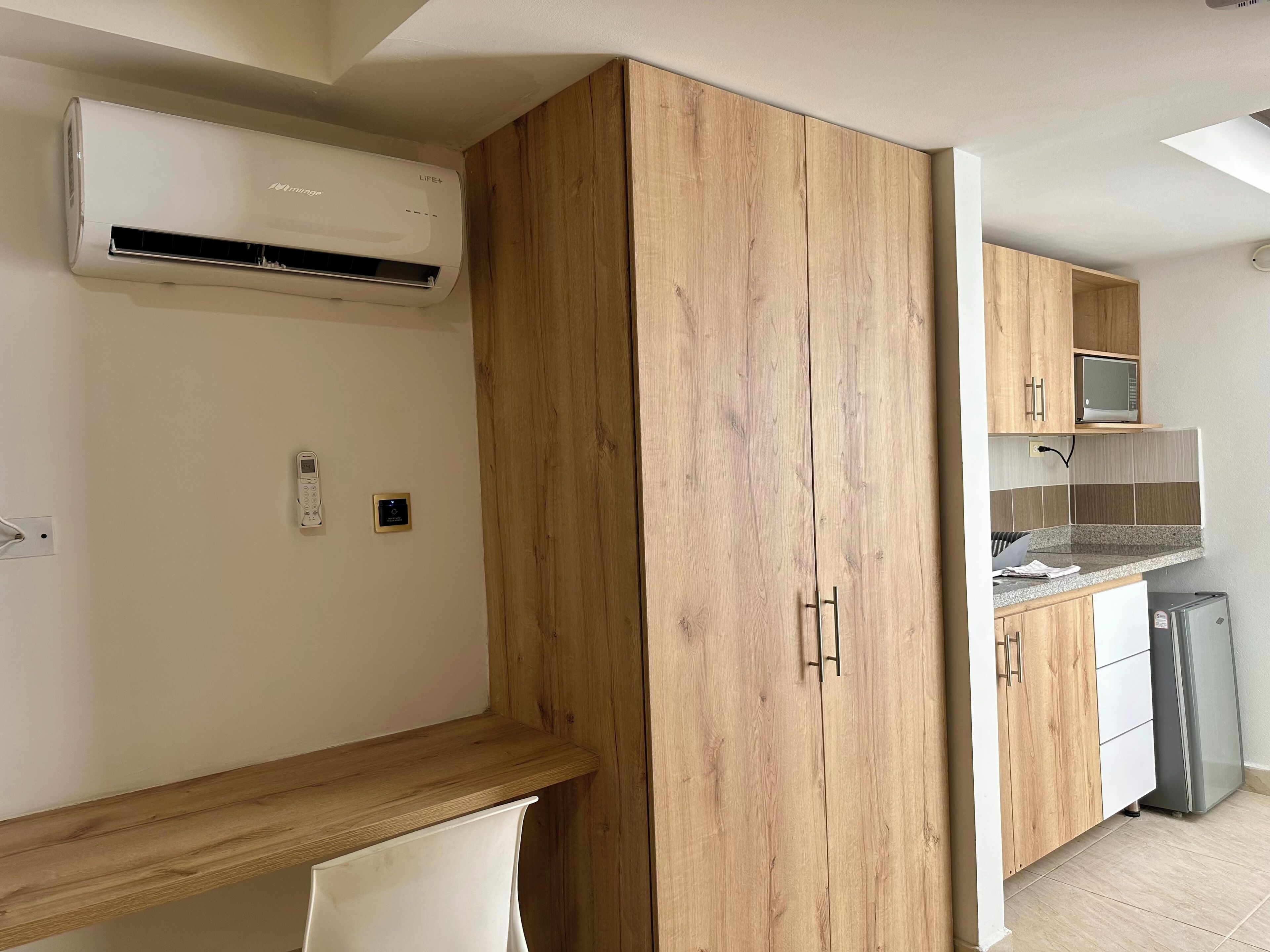 A kitchen with wooden cabinets, a built-in microwave, and a refrigerator.