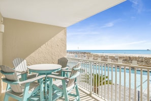Un balcon avec vue sur l’océan et une piscine.
