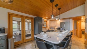 A spacious kitchen with a central island, wooden cabinets, and a large window. - Location Location  Location ! Resort Pools , Hot Tub ! MILLION DOLLAR VIEW !! (Gatlinburg)
