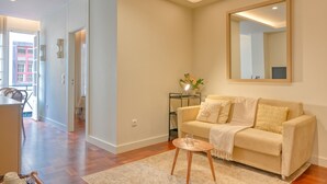 Una sala de estar con un sofá, una mesa de centro y un espejo en la pared.