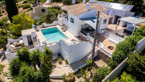 En modern villa med pool, utomhusmöbler och solpaneler.