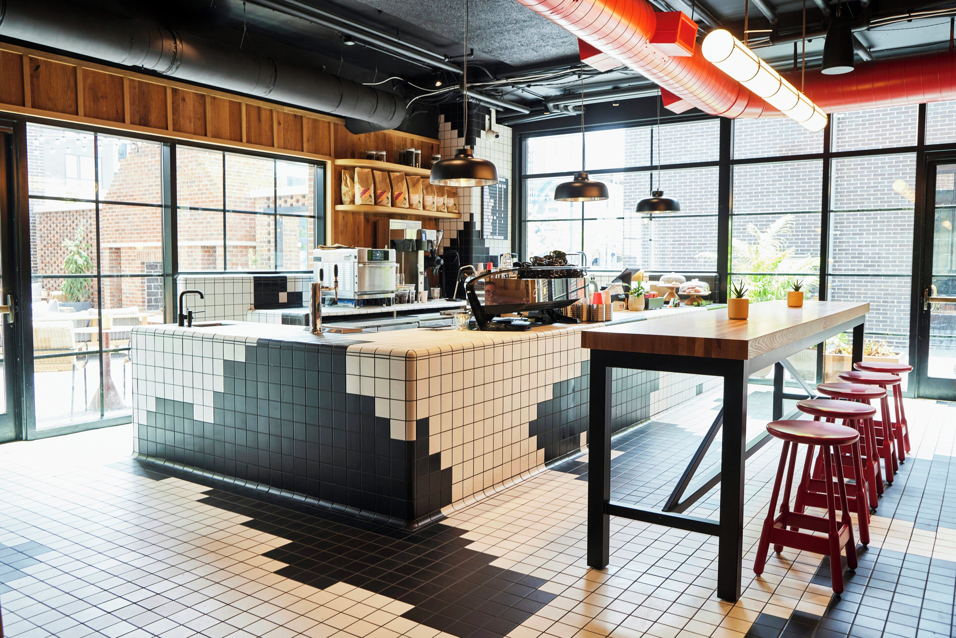 A modern kitchen with a large island, bar stools, and a view of the city.