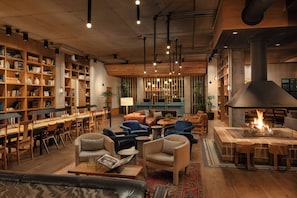 Un salón amplio con chimenea, estanterías y asientos cómodos.