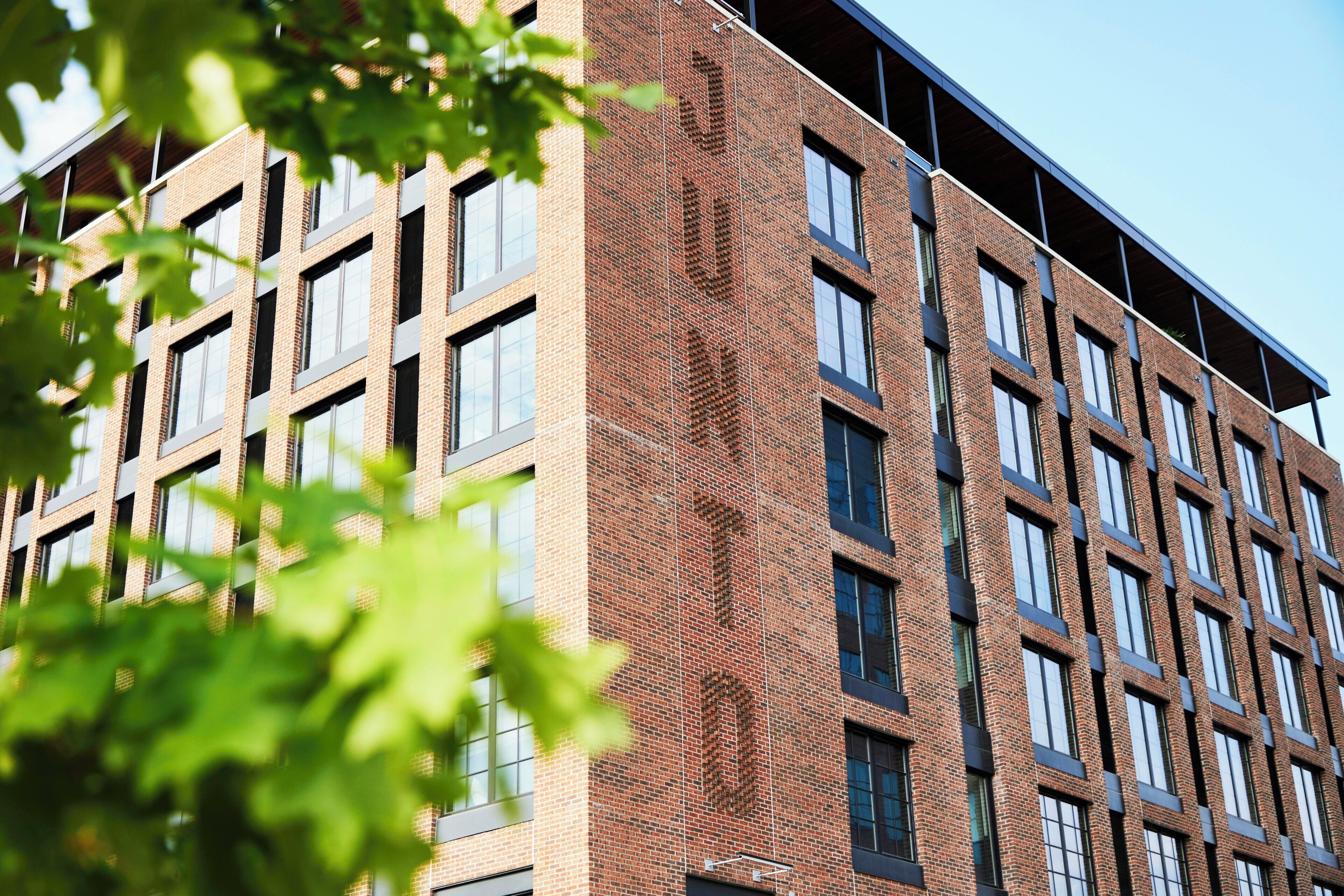 Un edificio de varios pisos con fachada de ladrillo y ventanas grandes.