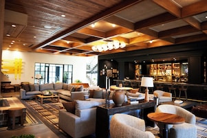 Ein stilvoller Lounge-Bereich mit Sofas, einem Couchtisch und einer Bar mit Flaschenregalen.