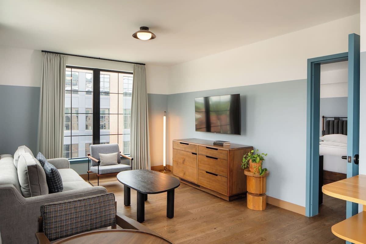 A modern living room with a sofa, a coffee table, a TV, and a wooden cabinet.
