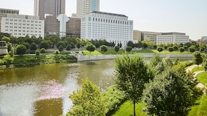 Un paisaje urbano con un río, un parque verde y edificios modernos.