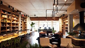 Una biblioteca amplia con estanterías, zonas de estar y chimenea.