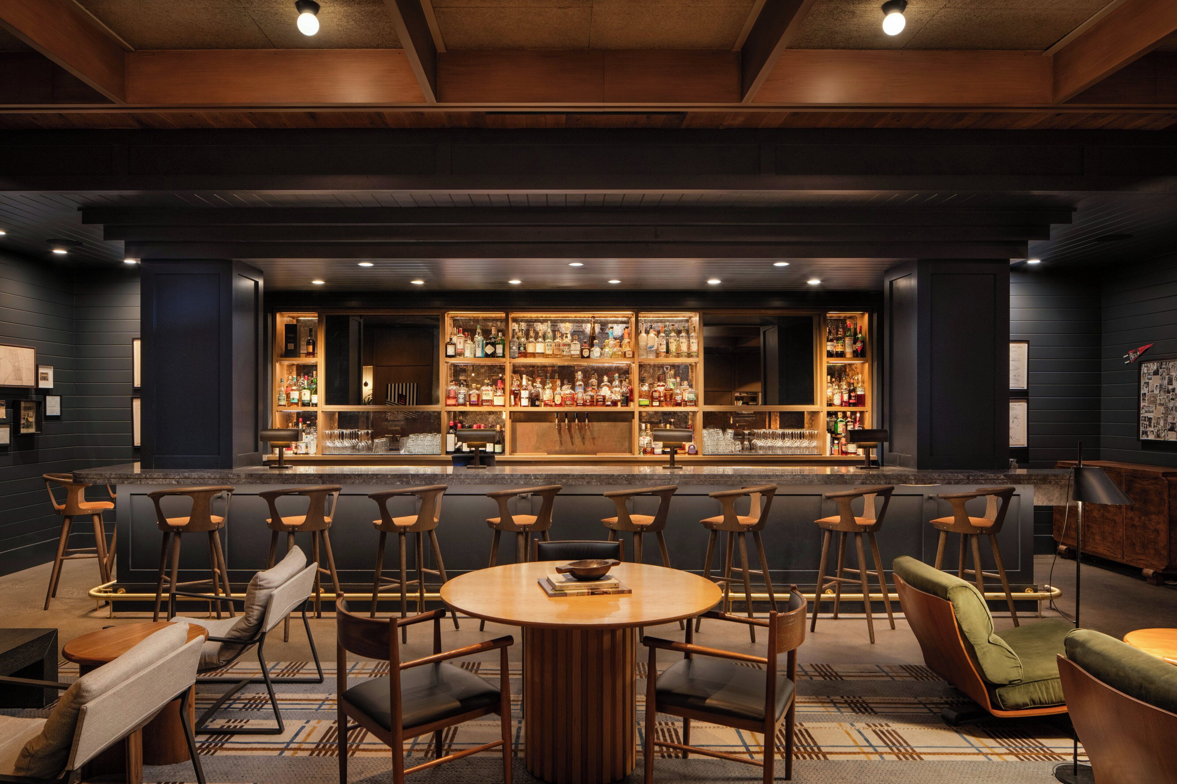 A bar area with multiple seating options, including bar stools and a round table.