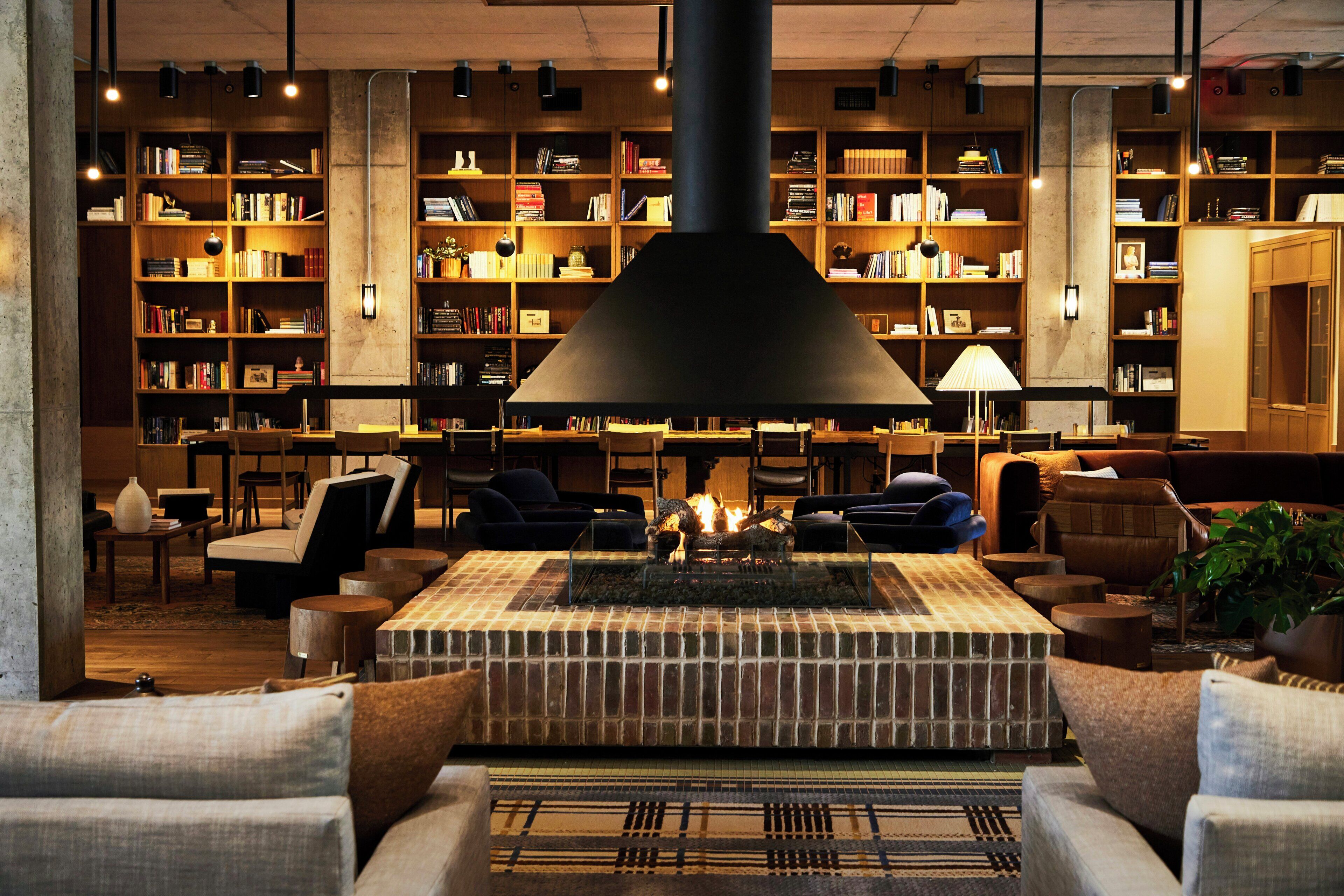 A library with bookshelves, a fireplace, and seating areas.