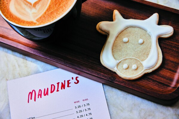 Un menú con el nombre 'MAUDINE'S' y una galleta con forma de gato.