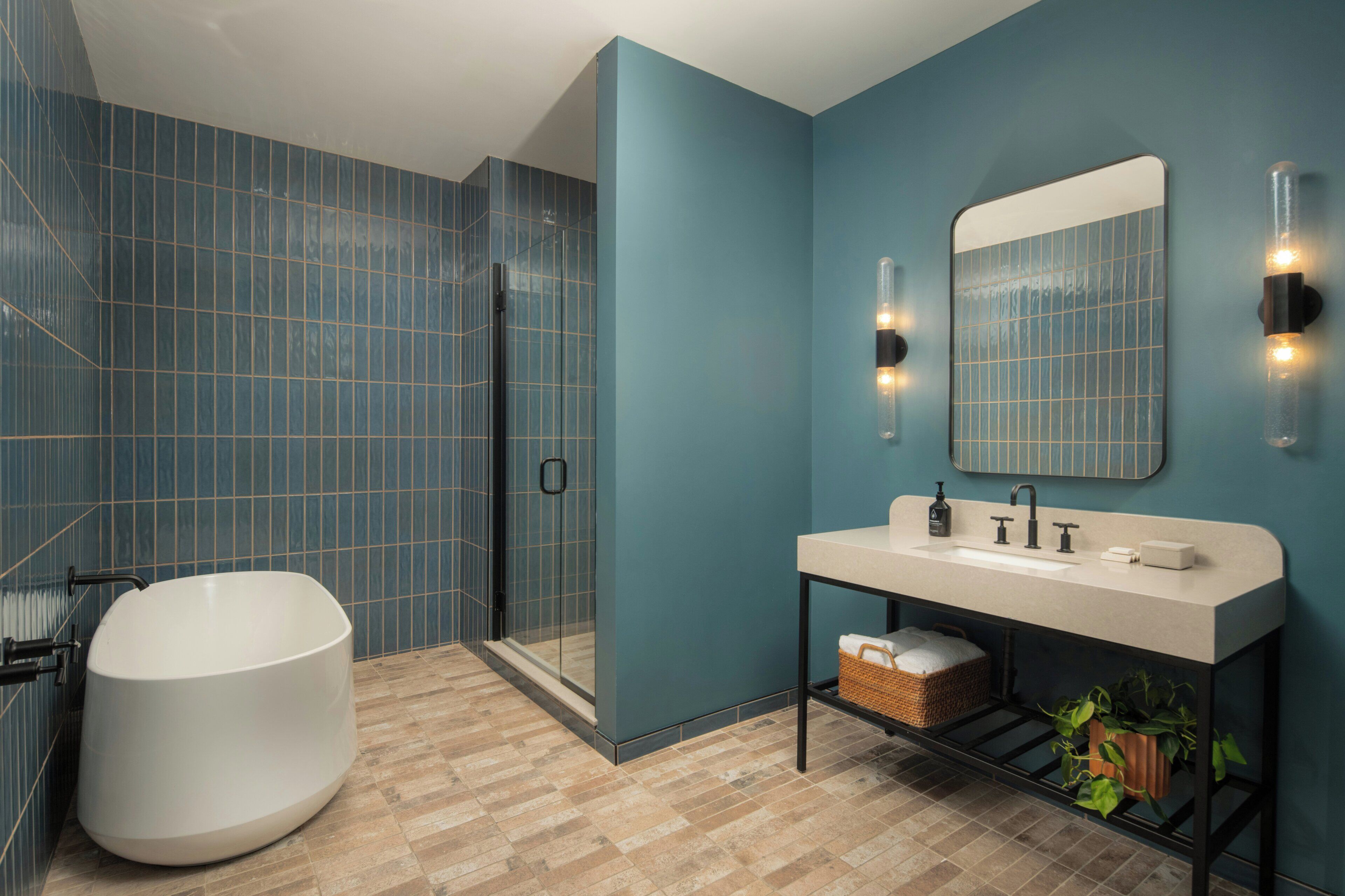 A modern bathroom with a large bathtub, a glass shower enclosure, and a vanity with a mirror and lighting.