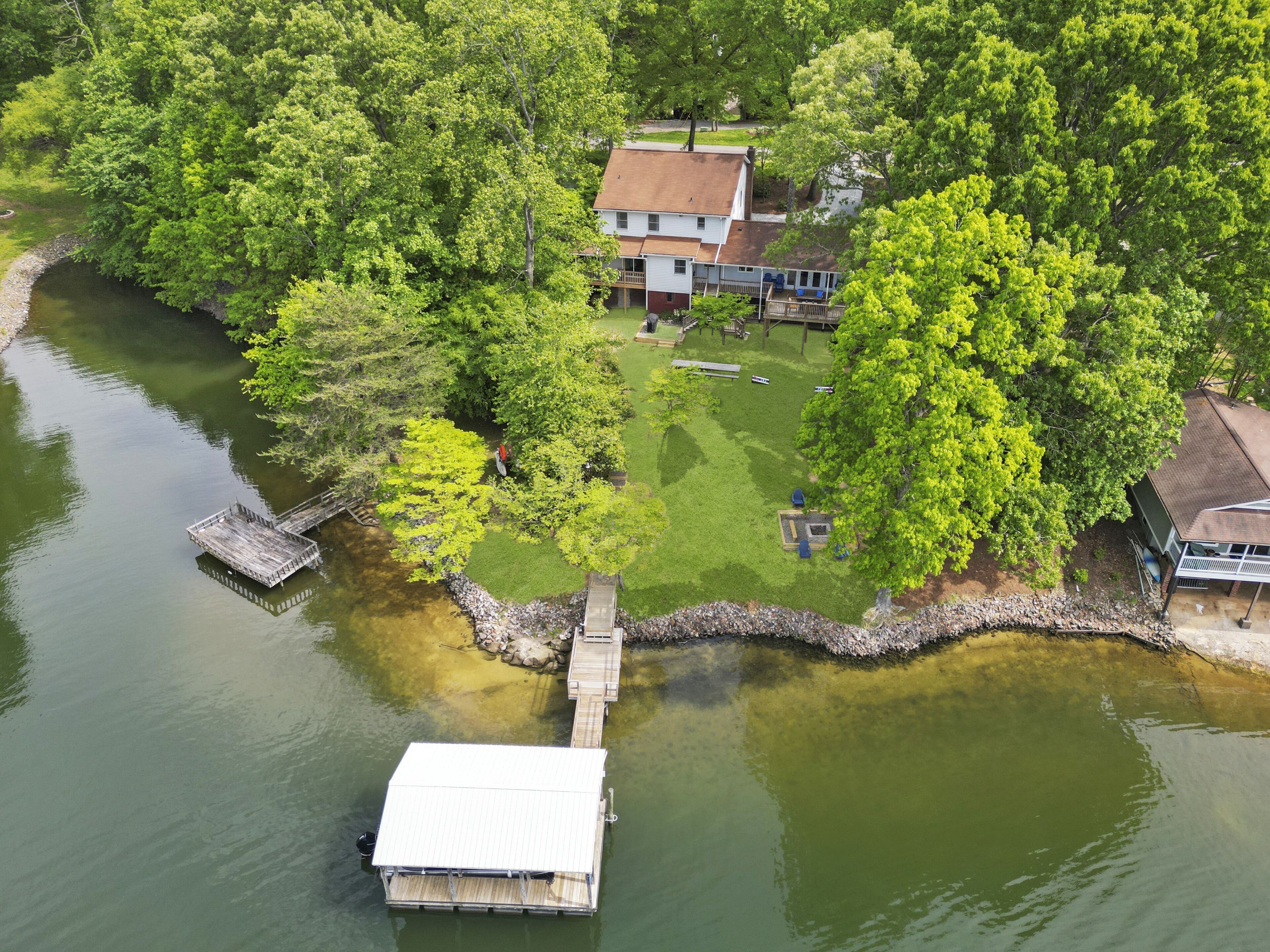 Une propriété au bord du lac, dotée d’un quai, d’une maison et d’une pelouse bien entretenue.